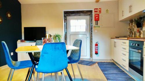 a kitchen with a table and blue chairs at Casa João Rodas in Soajo
