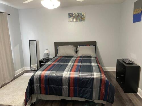 una camera da letto con un letto con una coperta scozzese di Cheerful 3-bedrooms with free parking on premises a Tallahassee