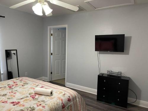 a bedroom with a bed and a flat screen tv at Cheerful 3-bedrooms with free parking on premises in Tallahassee