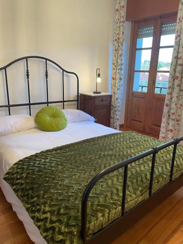 a bedroom with a bed with a green pillow on it at A Casa de Pia in Sober