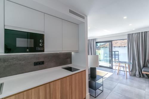 a kitchen with a counter top and a living room at Livemalaga Pedregalejo Suites in Málaga