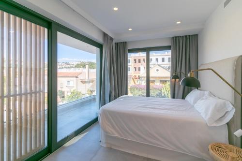 マラガにあるLivemalaga Pedregalejo Suitesのベッドルーム1室(ベッド1台、大きな窓付)