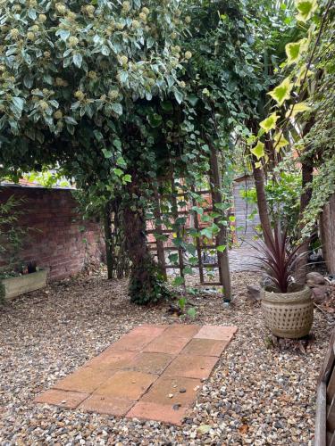 a garden with a brick wall and a brick walkway at Rooms In A Victorian Comfortable 4-bedroom house in Milton Keynes Rooms Not En-suites in Wolverton