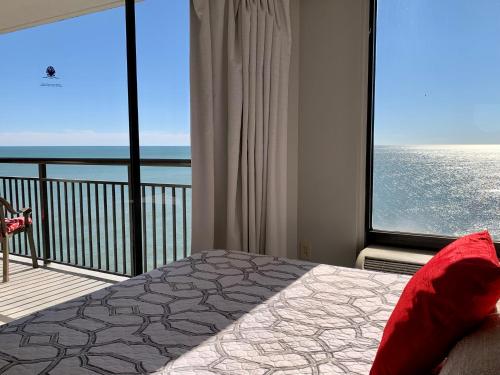 a bedroom with a large window with a view of the ocean at 1510 Pearl on the Beach Pet Friendly in Myrtle Beach