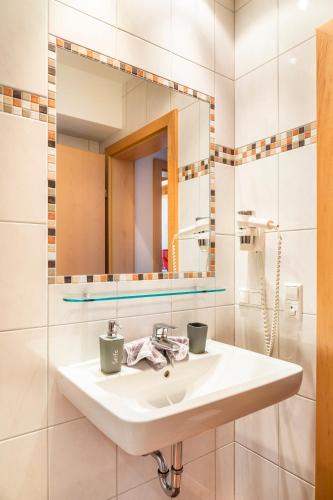 a bathroom with a sink and a mirror at Öko-Appartements Fallhaus in Forstau