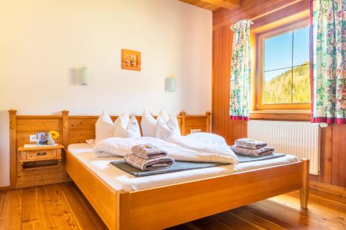 a bedroom with a bed with white sheets and a window at Öko-Appartements Fallhaus in Forstau