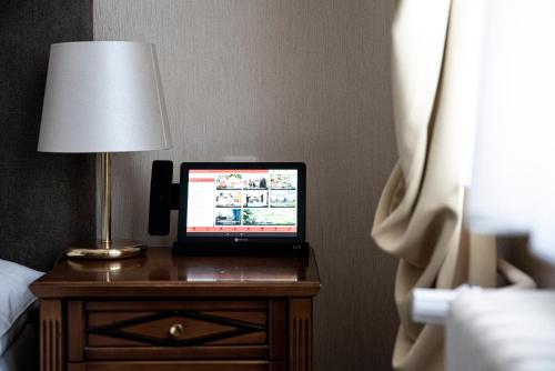 a laptop computer sitting on a table next to a lamp at Boutique-Hotel Amalienhof in Weimar