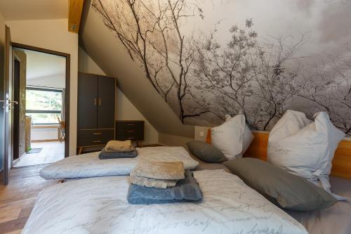 - 2 lits dans une chambre avec un tableau mural dans l'établissement Chalet Hüttenzauber, à Zella-Mehlis