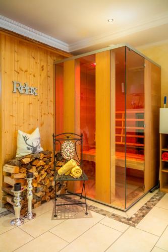 a glass shower in a room with wooden walls at Öko-Appartements Fallhaus in Forstau