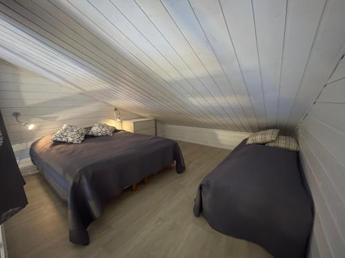 een kamer met 2 bedden en een plafond bij Syöte Luppomaja in Syöte