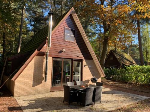 a small house with a table and chairs in front of it at Natuurhuis 'Van De Wereld' in Lanaken