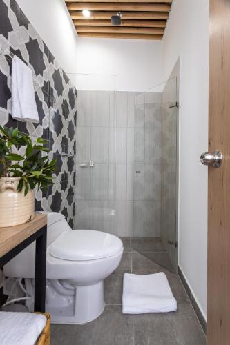 a bathroom with a toilet and a shower at Lexum by Bernalo Hotels in Medellín