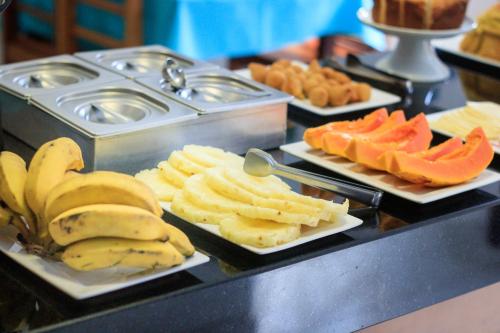 um buffet com bananas e outras frutas em pratos em Pousada Mangue Seco em Itaúnas