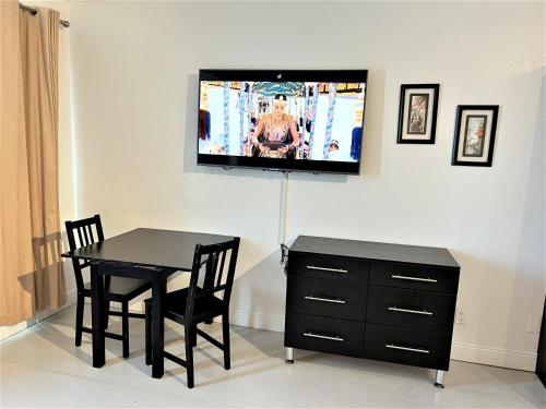 a dining room with a table and a tv on a wall at Ocean Front Units at Miami Beach in Miami Beach