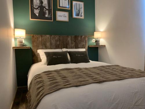 a bedroom with a large white bed with two pillows at LES GRENOUILLES in Amiens