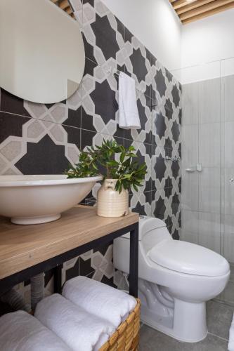 a bathroom with a white toilet and a sink at Lexum by Bernalo Hotels in Medellín