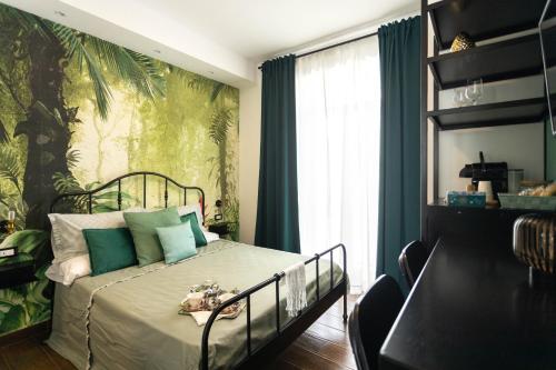ein Schlafzimmer mit einem Bett mit einer grünen Wand in der Unterkunft Il Sestante vista mare in Gaeta