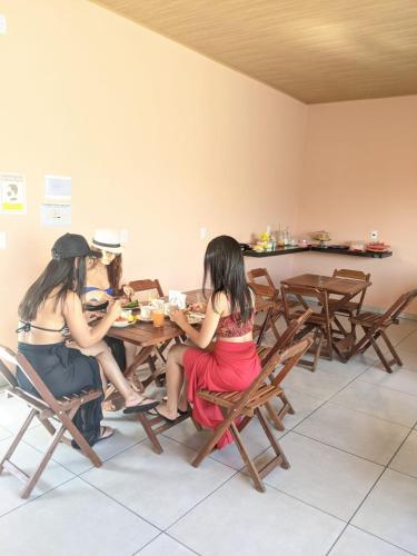 Due donne sedute a un tavolo in una stanza di POUSADA AMORIM a Santo Amaro