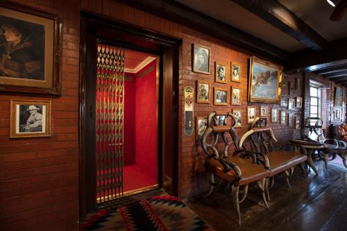 a room with chairs and portraits on the wall at Hotel El Rancho in Gallup