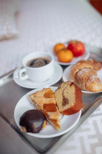 a tray with plates of pastries and a cup of coffee at Hotel Amico in Citta' Sant'Angelo