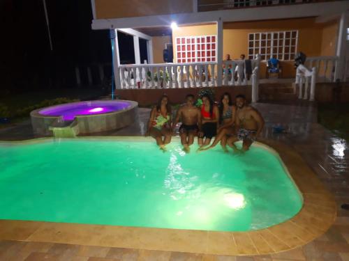 a group of people sitting in a swimming pool at night at FINCA CORENAS in La Cumbre