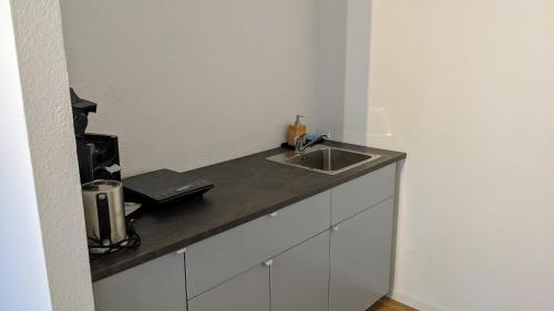 a kitchen with a sink and a counter top at Helle offene Innenstadtwohnung mit Balkon in Kirchheim unter Teck