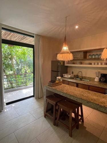 a kitchen with a island with a table and a counter top at Jungle View 2bed 2bath Condo/ Wi-Fi/ Pool/ Gym in Tulum