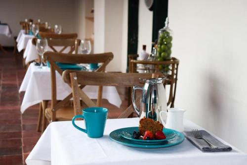 a table with a plate of cake and strawberries on it at Camino a Santa Fe in Guaduas