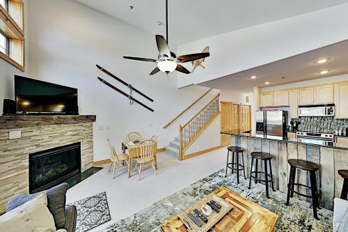 a living room with a ceiling fan and a fireplace at La Riva Del Lago 209 in Dillon