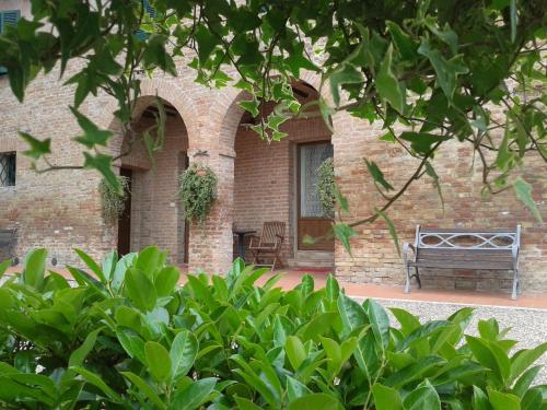 a bench sitting in front of a brick building at Agriturismo Il Poggiarello in Siena