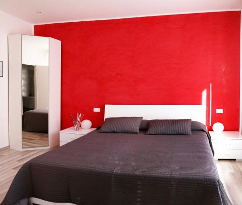 a bedroom with a red wall and a bed at Guest House Roma in Rome