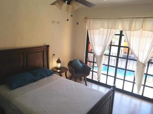 a bedroom with a bed and a large window at Hacienda Valentina in Playa del Carmen