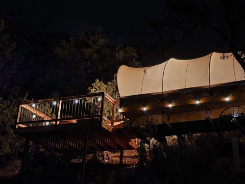 una casa en el árbol con techo por la noche en Zion View Camping, en Hildale
