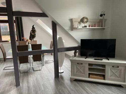 a living room with a flat screen tv and a staircase at Harzer Ferienlodge in Wernigerode