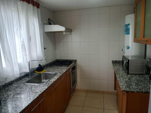 a small kitchen with a sink and a stove at Flamenco Bay Apartments in El Calafate