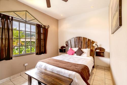 een slaapkamer met een bed met een houten hoofdeinde en een raam bij Downtown Suites in Boquete
