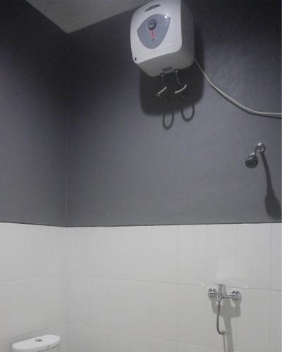 a bathroom with a toilet and a camera on the wall at JOGLO Greenhouse in Ngemplak