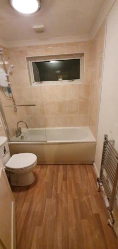 a bathroom with a toilet and a bath tub at Spacious and Serene Stay near Milton Keynes centre in Willen