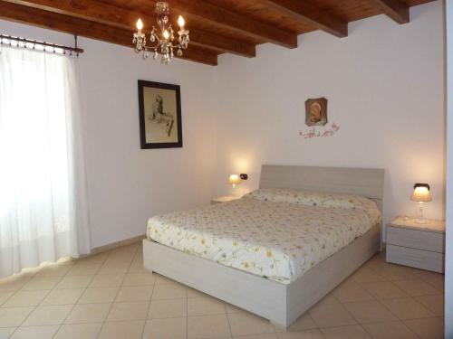 1 dormitorio con cama y lámpara de araña en Casa Rondinelle, en Castelveccana