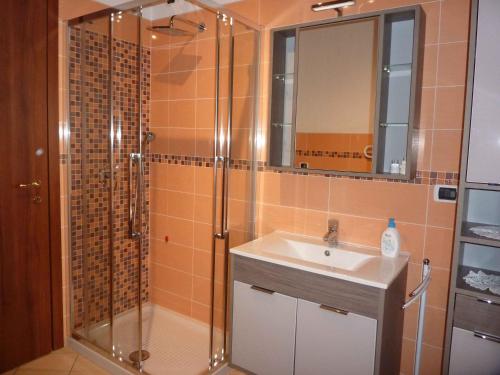 y baño con ducha, lavabo y espejo. en Casa Rondinelle, en Castelveccana