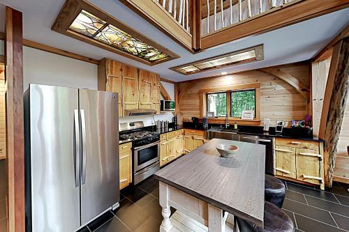 a kitchen with a stainless steel refrigerator and wooden cabinets at Lazy Lumberjack Grande in Franklin