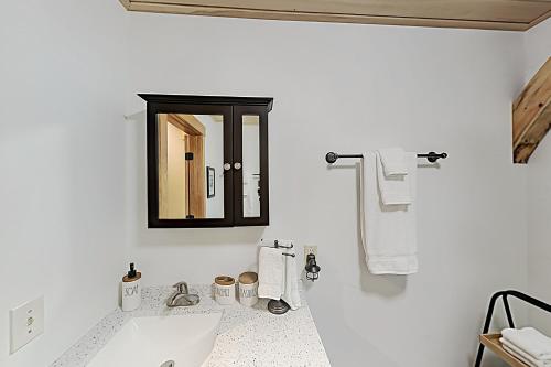 a white bathroom with a sink and a mirror at Lazy Lumberjack Grande in Franklin