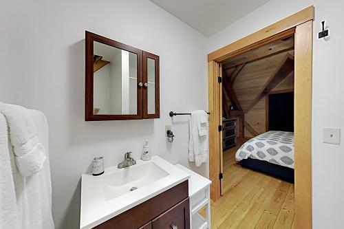 a bathroom with a sink and a bedroom with a bed at Lazy Lumberjack Grande in Franklin