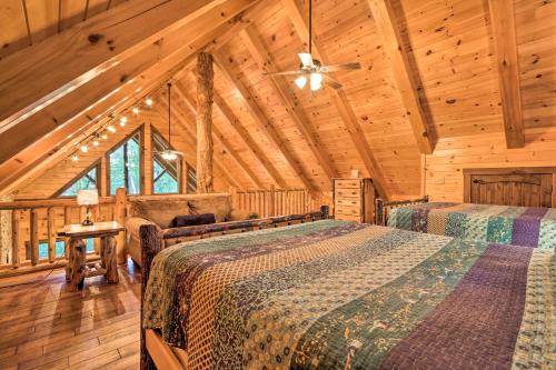 ローガンにあるSerenity Now Cabin with Fire Pit and Game Room!の丸太小屋のベッドが2つある寝室