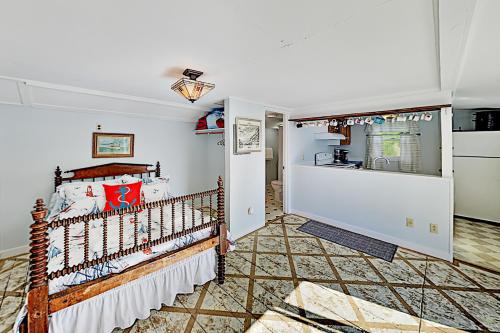 a bedroom with a bed and a kitchen at Atlantic Gardens in Boothbay Harbor