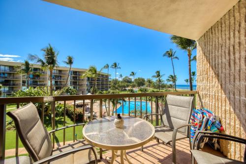 a balcony with a table and chairs and a view of the ocean at Maui Sunset A317 in Kihei