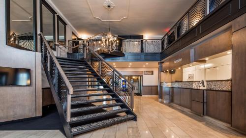 a spiral staircase in a lobby with a bar at Best Western Hotel Universel Drummondville in Drummondville