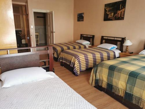 una habitación de hotel con 3 camas en una habitación en Hotel Rosim, en Latacunga