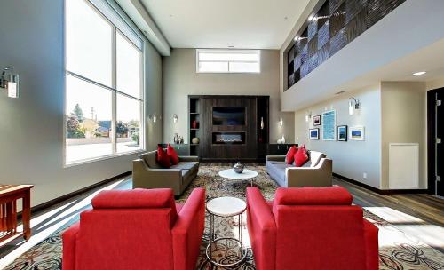 a living room with red furniture and a fireplace at Best Western Plus Osoyoos Hotel & Suites in Osoyoos