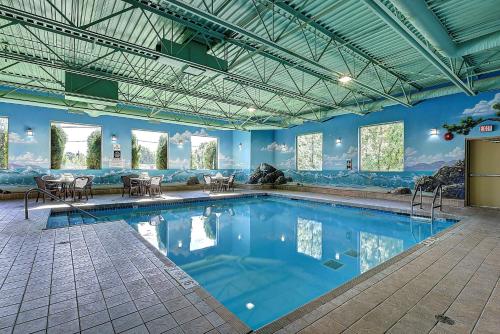 a large swimming pool with blue walls and windows at Best Western Plus Osoyoos Hotel & Suites in Osoyoos